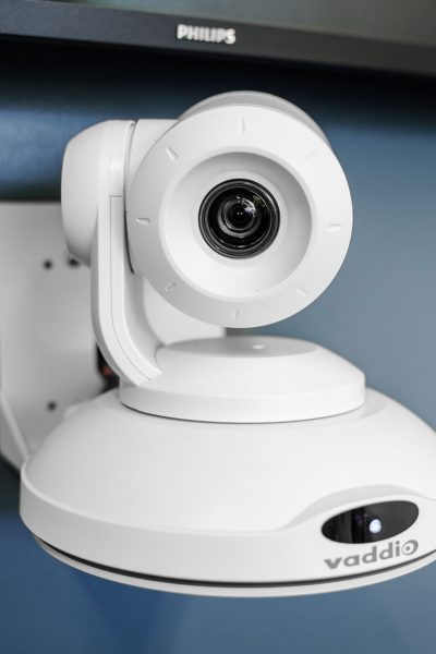 Closeup of a video conferencing camera mounted to a wall